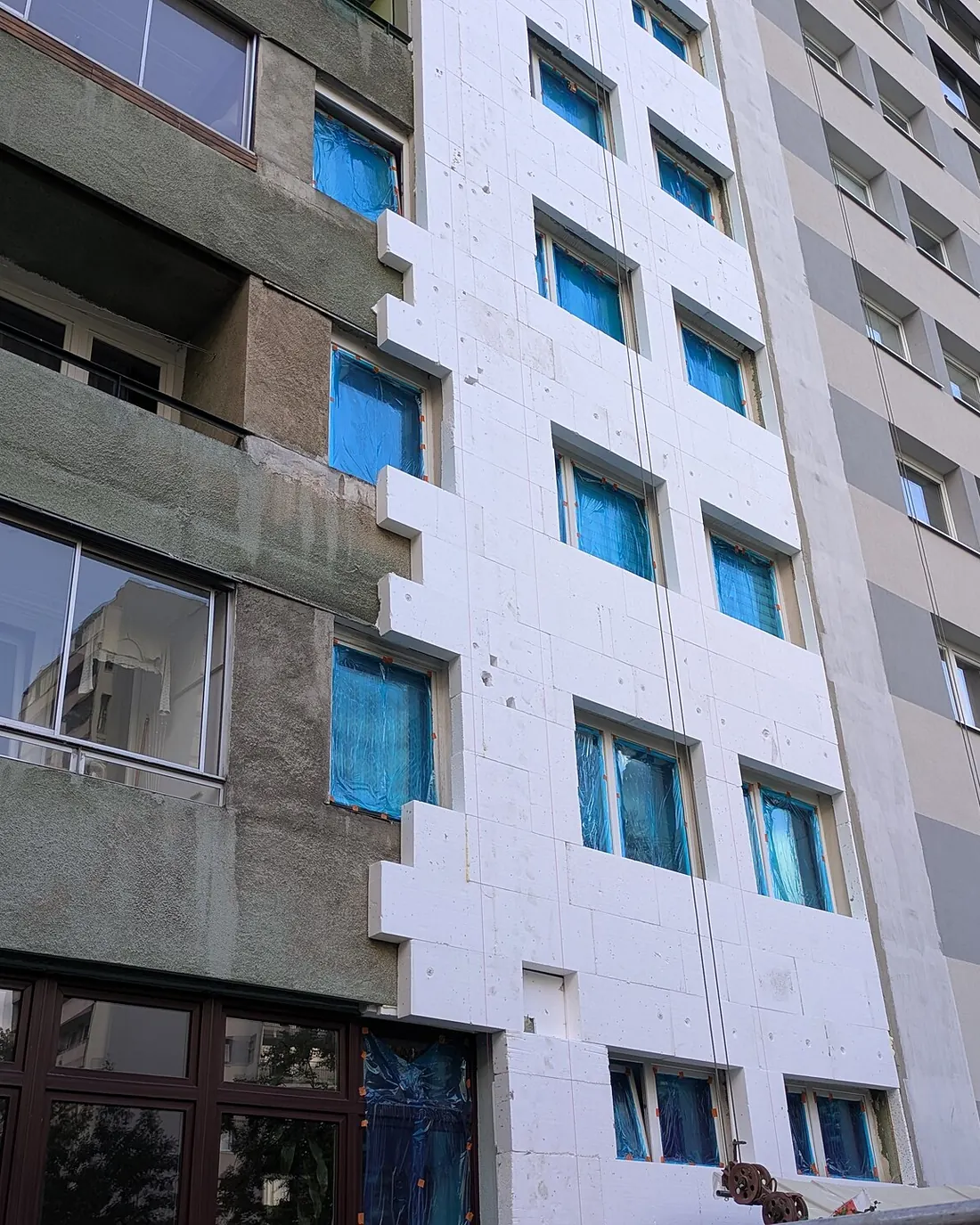 Blok mieszkalny w trakcie ocieplania elewacji styropianem